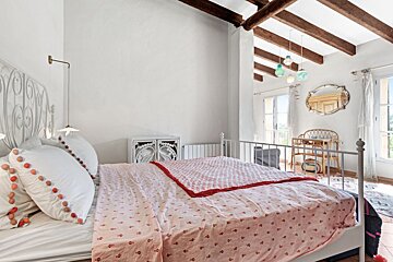 A bedroom with a large bed and a desk