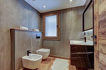 A bathroom with two toilets and a sink