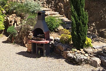 A bottle of olive oil sits next to a grill