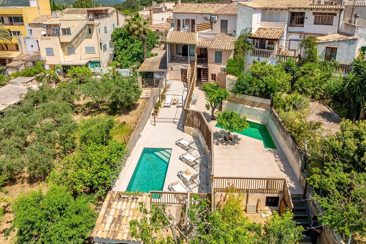 An aerial view of a house with a large swimming pool