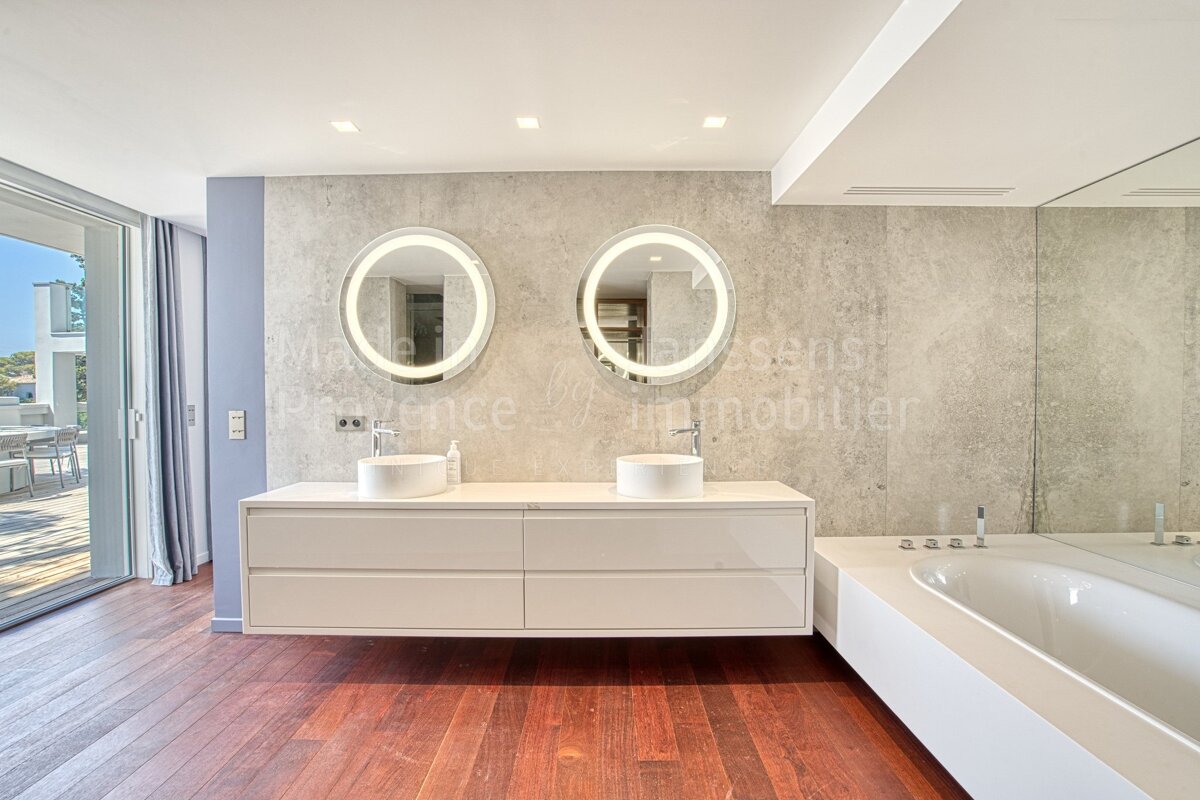 A bathroom with two sinks and a bathtub with the word immobilier on the wall