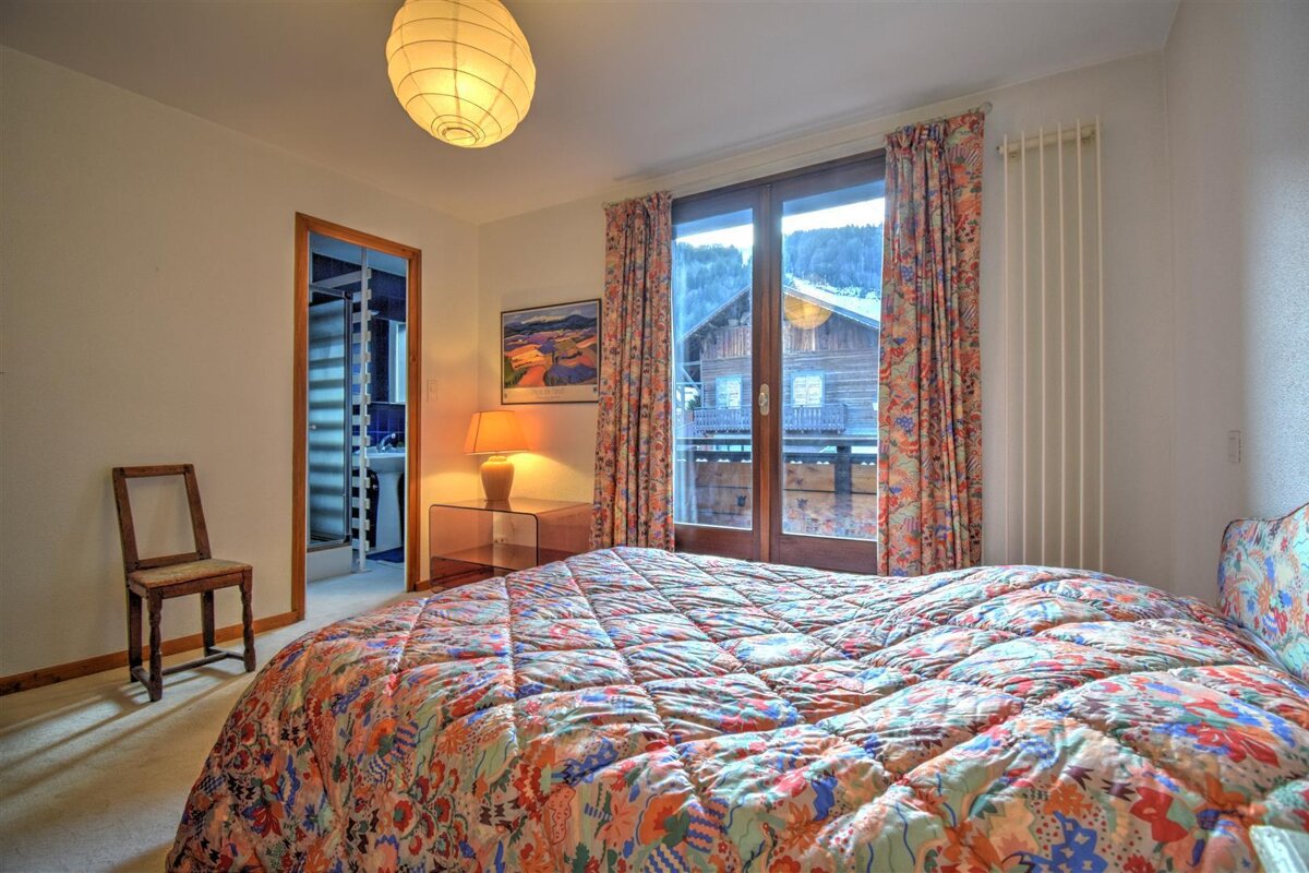 A bedroom with a large bed and a picture on the wall