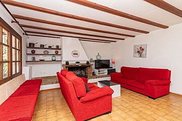 A living room with red furniture and a fireplace