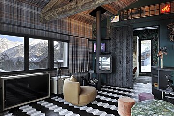 Eclectic mountain chalet living room with plaid walls, a geometric floor, stunning snowy mountain views, and a modern fireplace.