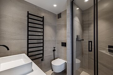 A bathroom with a walk in shower and a sink