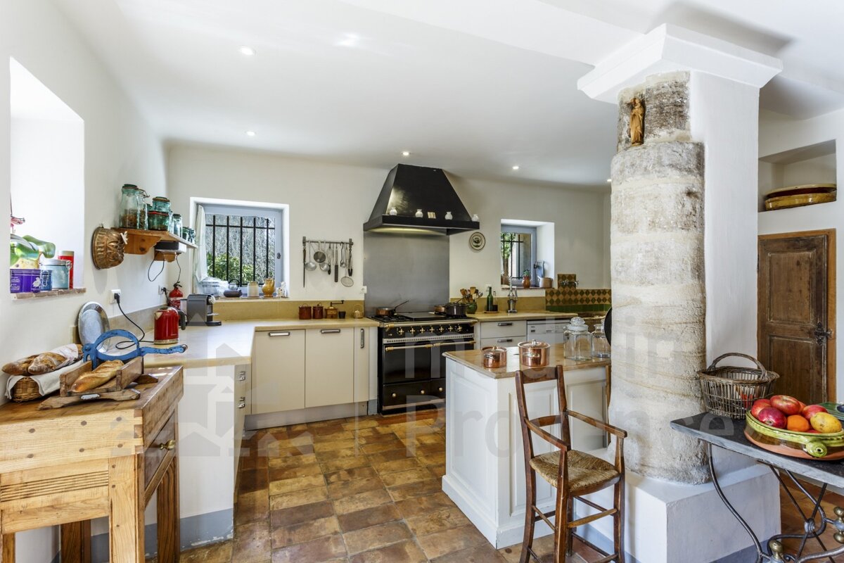 A kitchen with white cabinets and a black stove top oven