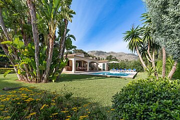 A house with a large swimming pool in front of it