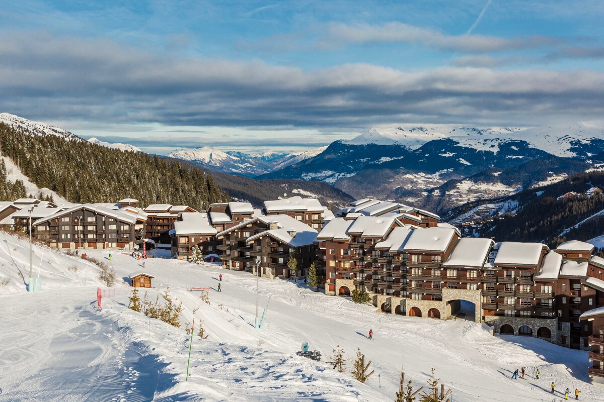 A snowy ski resort with mountains in the background