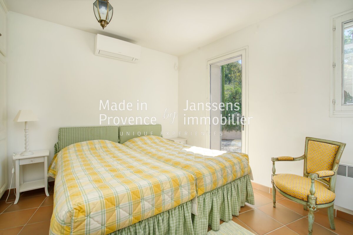 A bedroom with a bed and a chair that says made in provence
