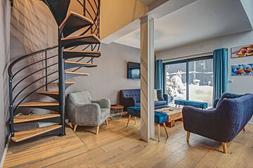 A living room with a spiral staircase and chairs