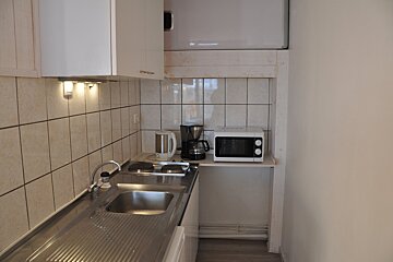 A small kitchen with a sink and a microwave