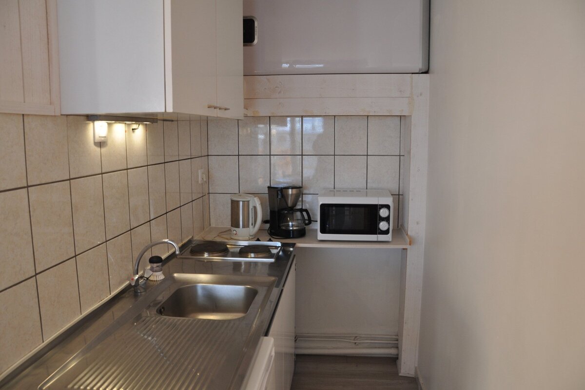 A small kitchen with a sink and a microwave
