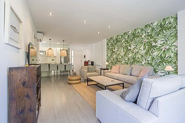 A living room with a tropical wallpaper on the wall