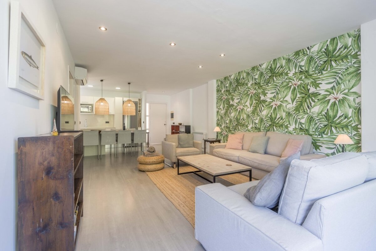 A living room with a tropical wallpaper on the wall