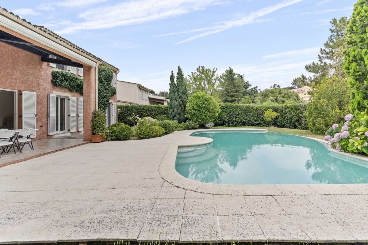 A large swimming pool in the backyard of a house