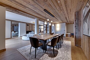 A dining room with a wooden table and chairs
