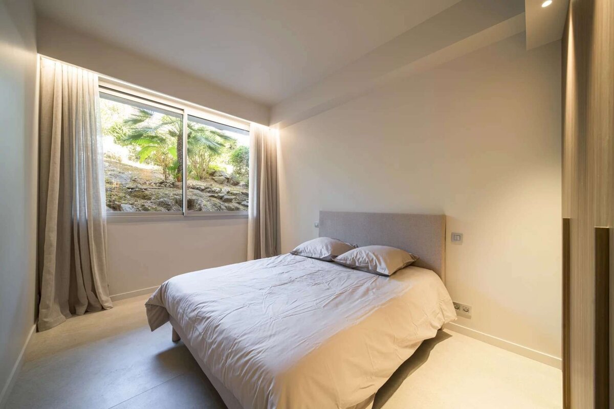 A bedroom with a large bed and a window