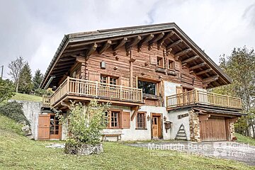 A mountain base real estate logo is on the side of a house