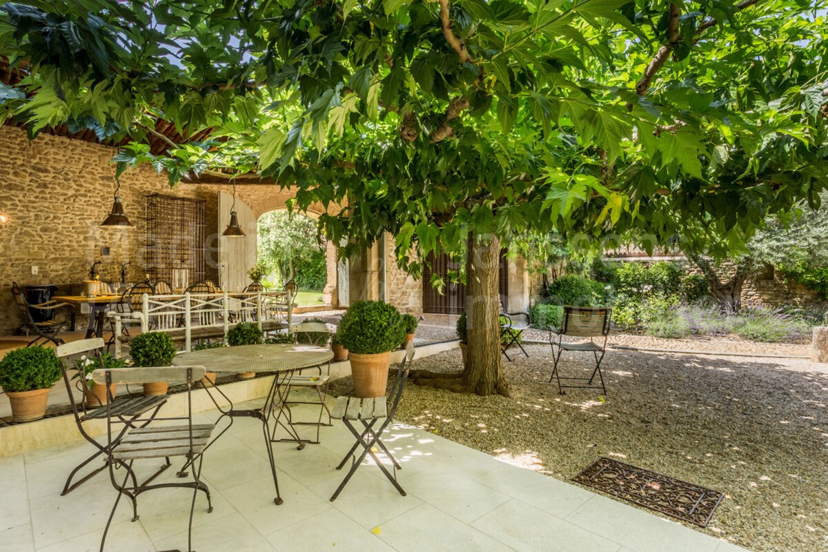 A patio with tables and chairs under a tree