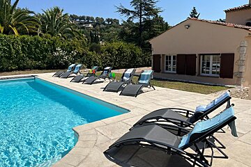 A row of lounge chairs sit near a swimming pool