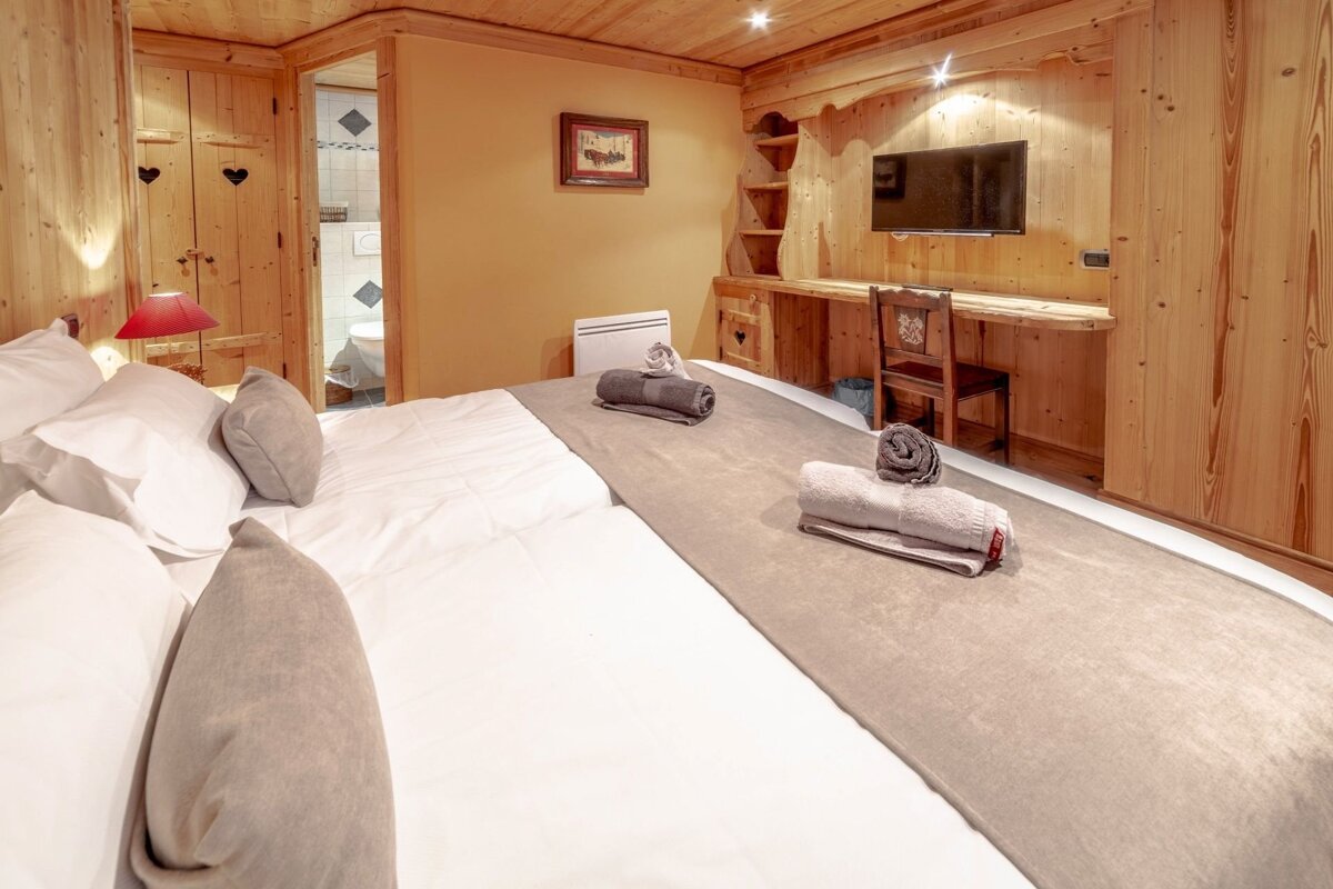 A bedroom with a large bed and a flat screen tv