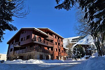 A snowy building with a blue sky in the background