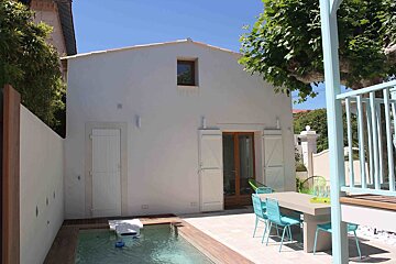 A white house with a swimming pool in front of it