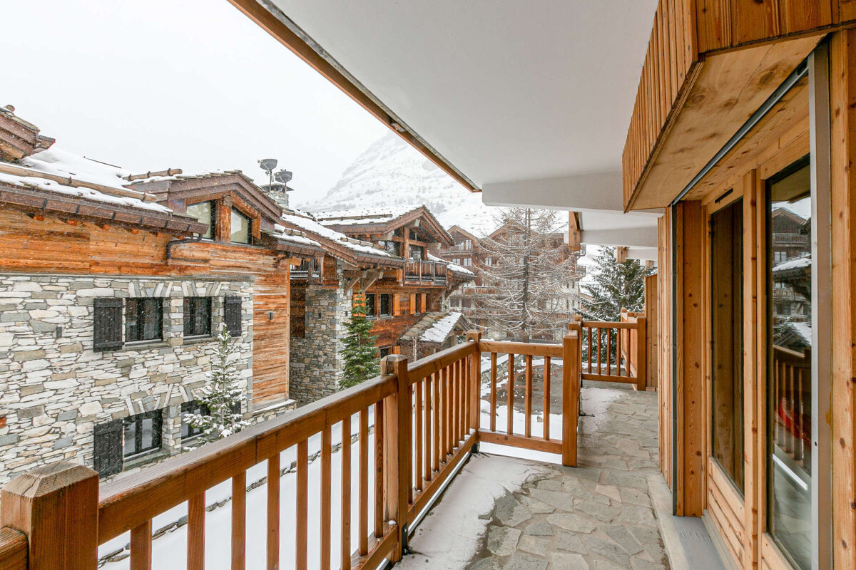 A balcony with a view of snow covered buildings