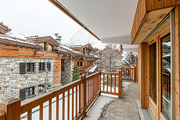 A balcony with a view of snow covered buildings