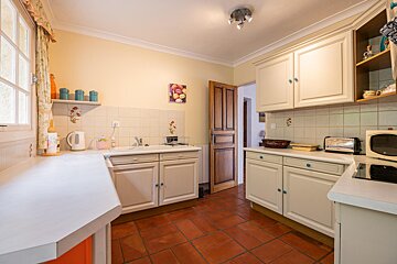 A kitchen with white cabinets and a picture of fruit on the wall