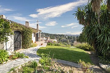 A stone walkway leads to a house on a hillside