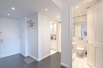 A hallway leading to a bathroom and a sink