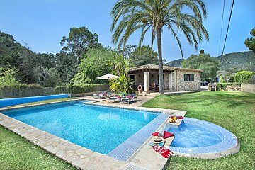A house with a pool and a hot tub in front of it