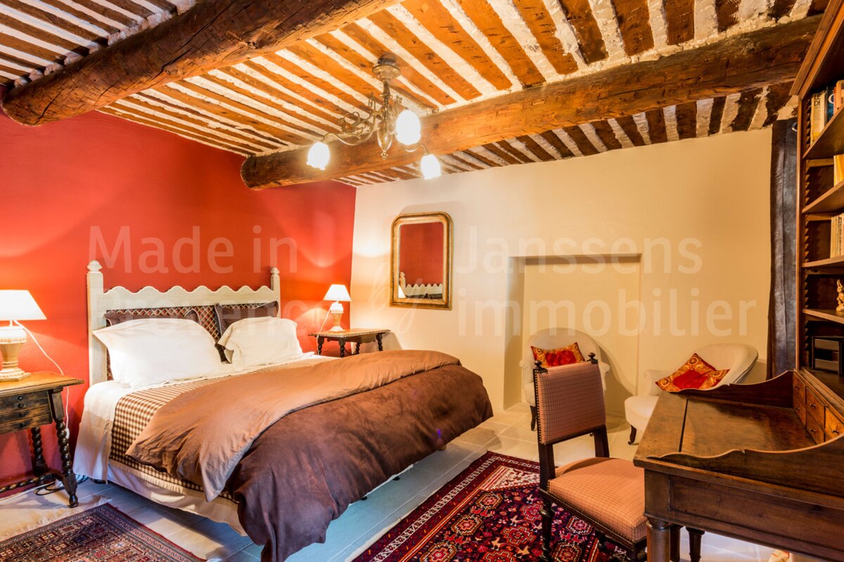 A bedroom with a bed and a ceiling made in janssens immobilier