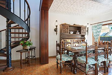 A dining room with a spiral staircase and a table and chairs