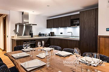 A kitchen with a table set for dinner and a sign that says mountain base high frank