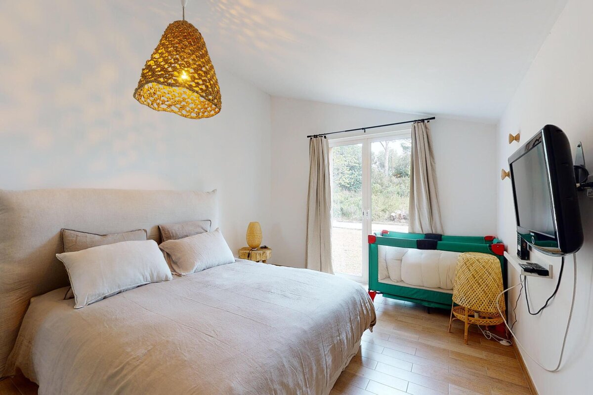 A bedroom with a large bed and a flat screen tv