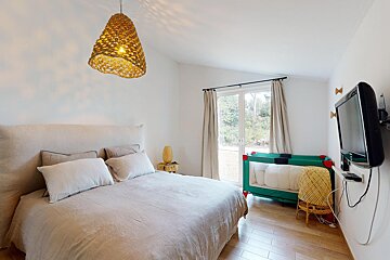 A bedroom with a large bed and a flat screen tv