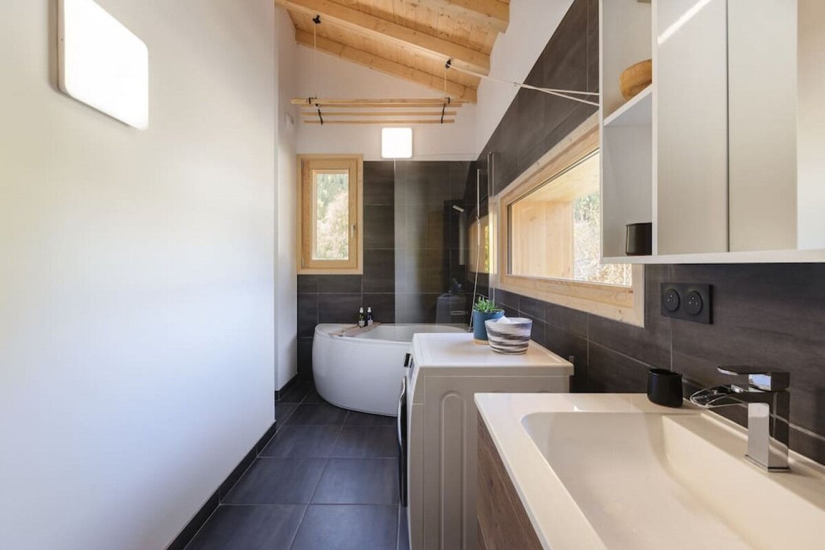 A bathroom with a tub and a sink and a window
