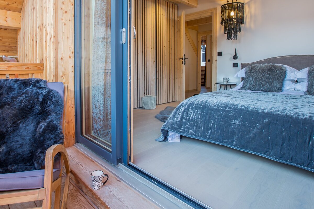 A bedroom with a bed and a sliding glass door
