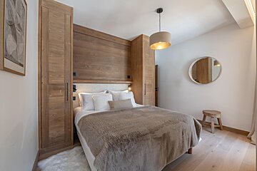 A bedroom with a bed and a mirror on the wall