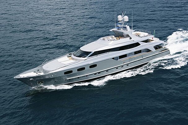 A large gray yacht is floating in the ocean