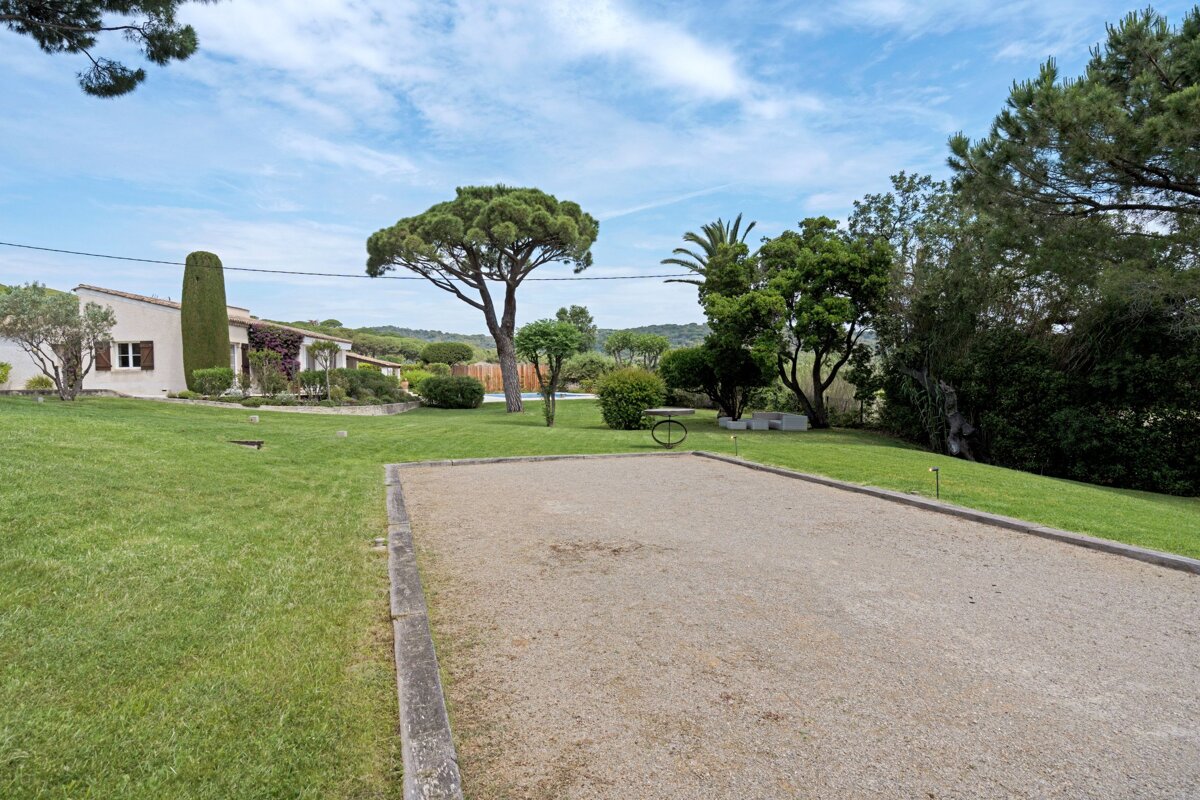 A lawn with a few trees and a house in the background