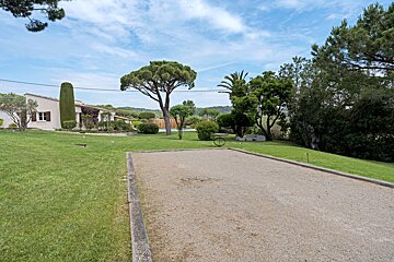 A lawn with a few trees and a house in the background