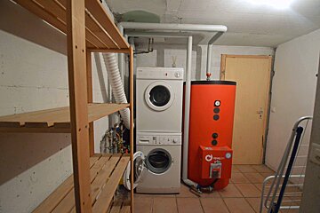 A washer and dryer are stacked on top of each other in a laundry room