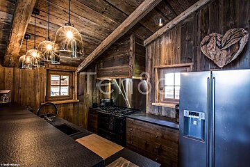 A kitchen with a stainless steel refrigerator and a heart on the wall