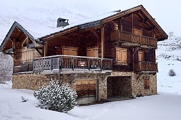 A snow-covered wooden chalet, named 