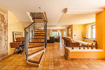 A living room with a spiral staircase leading up to the second floor