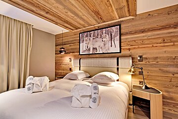 A hotel room with a picture of wolves on the wall above the bed