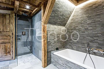 A bathroom with a bathtub and a shower with the number 80 on the wall